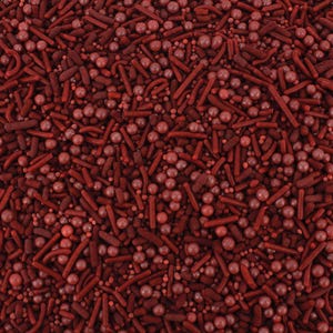 May include: Red and maroon sprinkles for baking and decorating. The sprinkles are a mix of small balls and long, thin sticks.