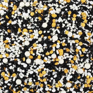 May include: A close-up shot of a mix of colorful sprinkles. The sprinkles include black, white, and gold shapes, including round, oval, and stick-like forms. These sprinkles are ideal for decorating cakes, cupcakes, and other baked goods.