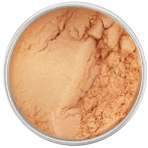 May include: A close-up view of a round, silver container filled with a light orange-brown powder. The powder has a fine texture and appears to be a cosmetic product, such as a blush or bronzer.