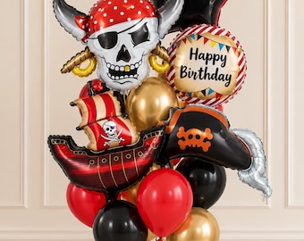 May include: A pirate-themed balloon bouquet featuring a large skull balloon with a red bandana, a ship balloon, a black pirate hat balloon, a star-shaped black balloon, and a round balloon with the text Happy Birthday, accented by red, black, and gold balloons.