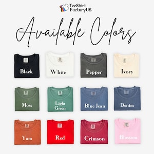 May include: A selection of folded t-shirts in various colors, including black, white, pepper, ivory, moss, light green, blue jean, denim, yam, red, crimson, and blossom. The text "Available Colors" is written above the shirts.