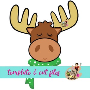 May include: A cartoon illustration of a brown moose with closed eyes wearing a green scarf with white polka dots. The moose has large, yellow antlers. The text "template & cut files" is at the bottom of the image.