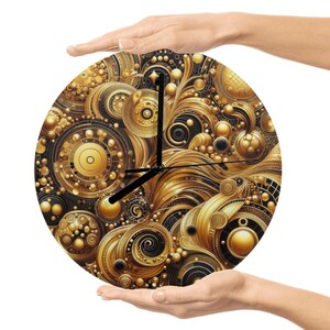 Puede incluir: Un reloj redondo con un diseño detallado en oro y negro. La esfera del reloj presenta patrones arremolinados, círculos y esferas. Las manecillas negras indican la hora. El reloj está sostenido por dos manos.