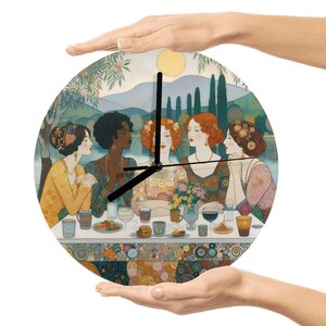 Puede incluir: Reloj de pared redondo con una ilustración de estilo art nouveau de cinco mujeres sentadas a la mesa. La esfera del reloj tiene un diseño colorido con un fondo de paisaje y manecillas negras. El reloj está sostenido por dos manos.