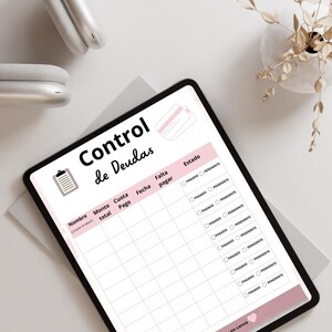 May include: A digital tablet displaying a debt tracker template with the title "Control de Deudas". The template includes fields for name, total amount, payment, date, and status. The design features a pink and white color scheme.