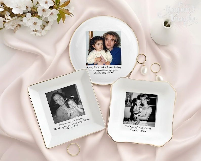 May include: Three white ceramic trinket dishes with gold-toned rims, each featuring a personalized black and white photograph and handwritten-style text. One round dish and two square dishes display family photos with dates and messages.