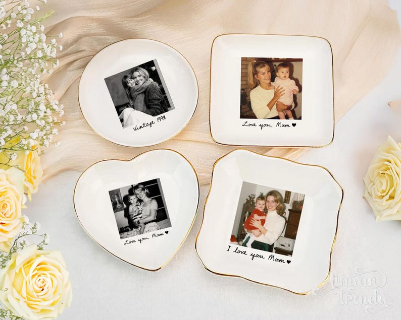 May include: Four white ceramic trinket dishes with gold-painted rims, each featuring a custom black and white photograph in the center. The dishes are round, square, heart-shaped, and square with wavy edges, each inscribed with handwritten text.