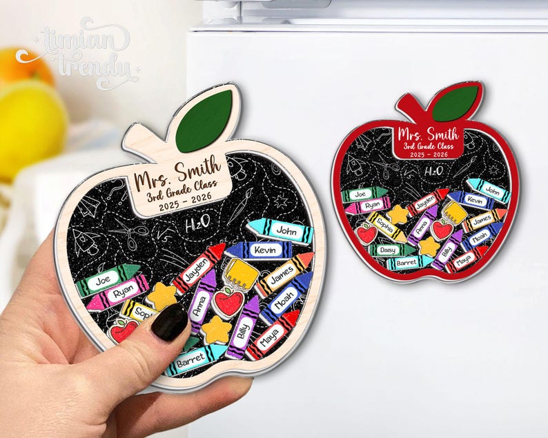 May include: Two apple-shaped magnets. One is held by a hand. The magnets have a chalkboard design with the text "Mrs. Smith 3rd Grade Class 2025-2026" and student names. Colorful crayon and apple details are included.