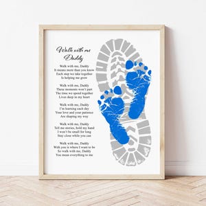 Pode incluir: Impressão emoldurada com o texto "Walk with me Daddy" e um poema. A obra apresenta uma pegada de bota cinza com pegadas azuis no interior. A moldura é de cor de madeira clara.