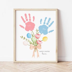 K&ouml;nnte beinhalten: Eine druckbare Osterkarte mit zwei Handabdr&uuml;cken in Rosa und Blau, die einen Blumenstrau&szlig; mit pastellfarbenen Eiern und dem Text "Frohe Ostern Liebe." bilden.