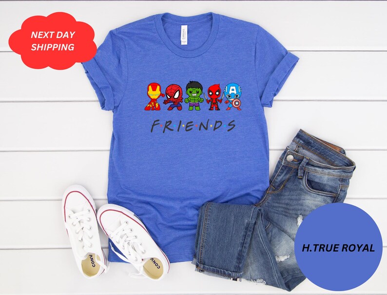 Puede incluir: Una camiseta azul con un gr&aacute;fico del logotipo de "Friends" y superh&eacute;roes de dibujos animados. Los superh&eacute;roes son Iron Man, Spiderman, Hulk, Thor y Captain America. El texto "FRIENDS" est&aacute; debajo de los superh&eacute;roes.