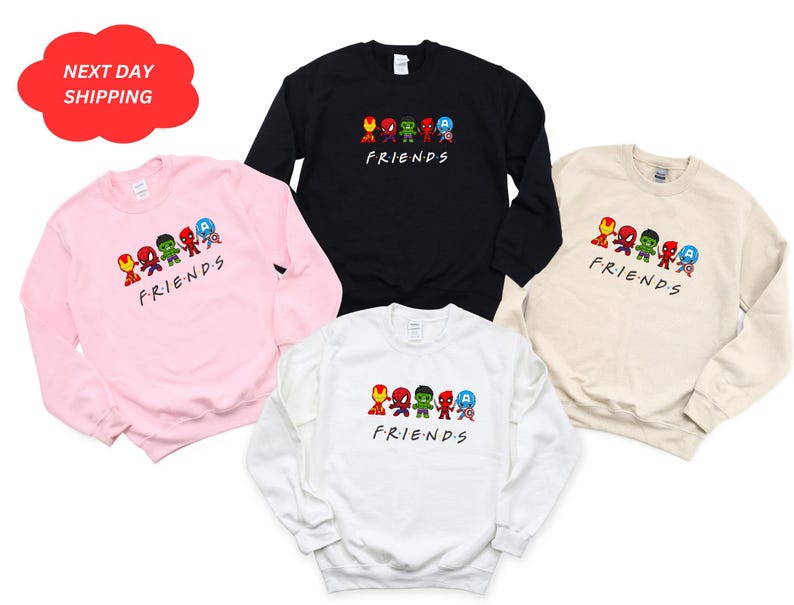 Pu&ograve; includere: Quattro felpe con collo rotondo in rosa, nero, beige e bianco con una grafica di supereroi dei cartoni animati in fila con la parola "FRIENDS" sotto.