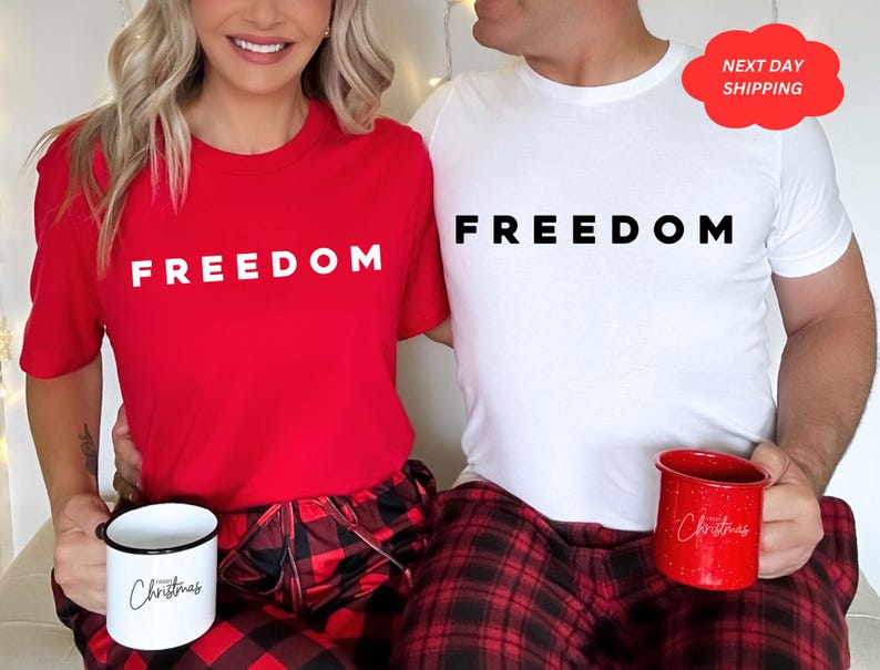 May include: A red t-shirt with the word "FREEDOM" in white, paired with red and black plaid pajama pants. A white mug with "Christmas" in black script is held. A white t-shirt with "FREEDOM" and a red mug with "Christmas" are also shown.