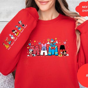 Puede incluir: Sudadera roja con un gr&aacute;fico de Mickey Mouse y sus amigos deletreando "MAMA" con estrellas y globos. Las mangas tienen una l&iacute;nea de personajes de Mickey Mouse con el texto "Name 1 Name 2 Name 3 Name 4 Name 5 Name 6".