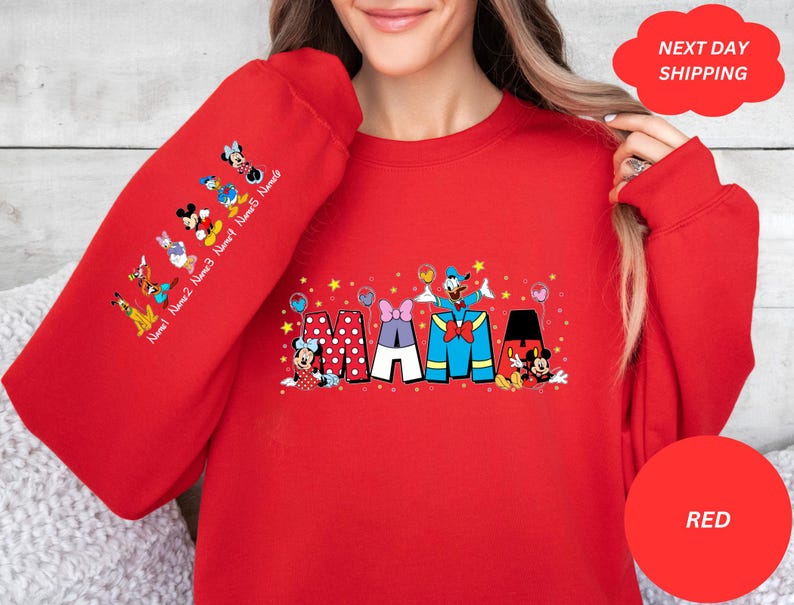 Puede incluir: Sudadera roja con un gr&aacute;fico de Mickey Mouse y sus amigos deletreando "MAMA" con estrellas y globos. Las mangas tienen una l&iacute;nea de personajes de Mickey Mouse con el texto "Name 1 Name 2 Name 3 Name 4 Name 5 Name 6".