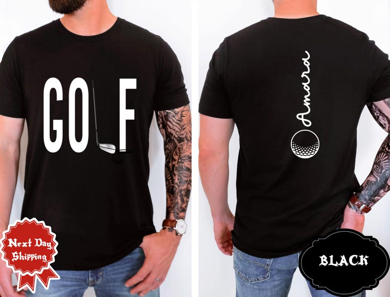May include: Black t-shirt with the word "GOLF" in large white letters and a golf club graphic. The back of the shirt features the name "Amara" in white script above a golf ball graphic. The shirt is black.