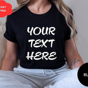 Könnte beinhalten: Schwarzes T-Shirt mit dem weißen Text "YOUR TEXT HERE", einer roten Wolkengrafik mit der Aufschrift "NEXT DAY SHIPPING" und einem schwarzen Kreis mit dem Wort "BLACK". Das Shirt hat kurze Ärmel.