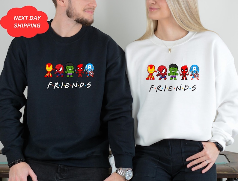 Pu&ograve; includere: Una coppia di felpe nere e bianche con una grafica di supereroi dei cartoni animati e la parola "FRIENDS" stampata sul davanti.