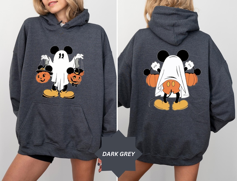 May include: Dark grey hoodie featuring a Halloween-themed graphic. The front displays Mickey Mouse dressed as a ghost, holding jack-o'-lanterns. The back shows Mickey Mouse with a ghost sheet and pumpkins. The hoodie has a kangaroo pocket.