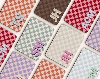 May include: Several rectangular items with a checkered design in shades of orange, brown, red, and blue. Each item displays initials like "TS", "JH", and "ACM" in a contrasting colour. The items are arranged on a light background.