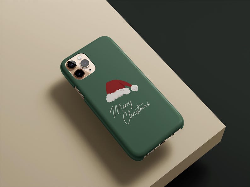 May include: A green phone case featuring a red and white Santa hat illustration and the words "Merry Christmas" in a handwritten style. The case is designed for a smartphone.