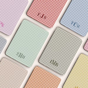 Peut inclure: Ensemble de dessous de verre personnalisés aux couleurs pastel, chacun avec un motif vichy et un monogramme. Les couleurs incluent le rose, le rouge, le bleu, le vert, le gris, l'orange et le jaune. Les dessous de verre sont rectangulaires.
