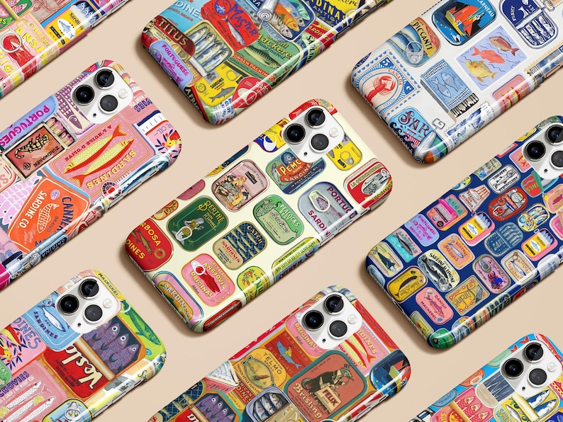 Może przedstawiać: Kolekcja etui na telefony z kolorowymi wzorami inspirowanymi puszkami sardynek w stylu vintage. Każde etui ma unikalny układ etykiet z tekstem i ilustracjami, prezentującym r&oacute;żnorodne marki i style. Etui są ułożone na jasnobeżowej powierzchni.