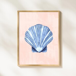 Könnte beinhalten: Ein gerahmter Druck eines blauen Muschel auf rosa Hintergrund. Die Muschel ist eine Aquarell-Illustration.