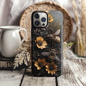 May include: Black phone case with a floral design featuring bees and yellow flowers. The case has a camera lens cutout and a black background.