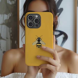 May include: A yellow phone case with a black and yellow bee illustration.