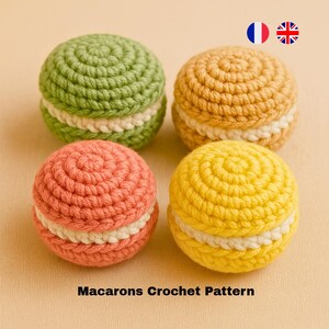 Könnte beinhalten: Vier gehäkelte Macarons in verschiedenen Farben: grün, gelb, orange und hellbraun. Jedes Macaron hat eine weiße gehäkelte Füllung.