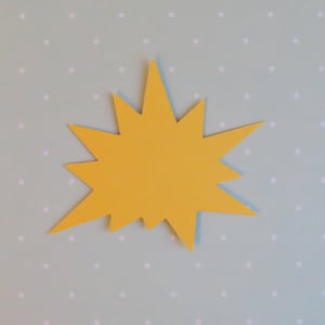 May include: A yellow paper starburst shape on a light blue background with white polka dots.