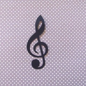 May include: Black treble clef cutout on a white polka dot background.