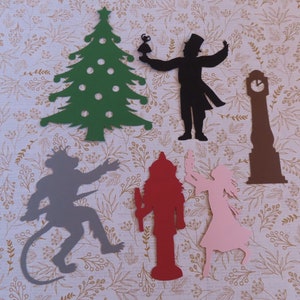 May include: A set of paper cutouts featuring characters from the classic Christmas story, The Nutcracker. The set includes a green Christmas tree, a black silhouette of the Nutcracker, a gray silhouette of the Mouse King, a red silhouette of the Nutcracker soldier, a pink silhouette of Clara, and a brown silhouette of a clock tower.