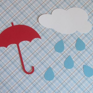 May include: A red paper umbrella with a white cloud and blue raindrops on a blue and white plaid background.