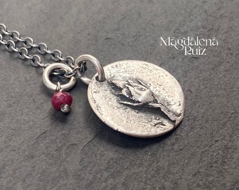 Authentic rose bud cast medallion with a rustic natural ruby.