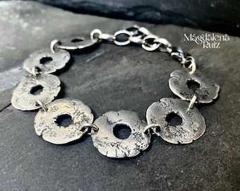 Brutalist raw silver bracelet made with open cracked texture disks.