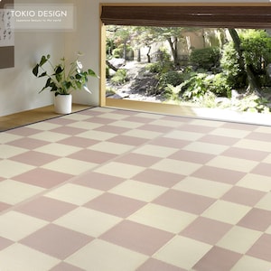 May include: A checkered tatami mat floor with alternating light beige and light pink squares. The mat is in a room with a large window overlooking a Japanese garden.