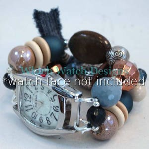 May include: A silver watch face holder with a beaded bracelet. The bracelet features a variety of beads in shades of brown, blue, and silver, with wooden and faceted beads. The text "watch face not included" is visible.