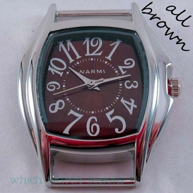 May include: A silver watch with a brown face and white Roman numeral hour markers. The watch face also has a smaller circle with the word "NARMI" printed on it.