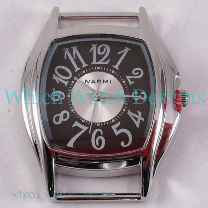 May include: A silver watch with a black face and white Roman numeral hour markers. The watch face also has a smaller silver circle with the word "NARMI" printed on it. The watch has a silver band.