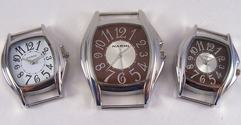 May include: Three silver-toned wristwatches with brown faces. The watches have Roman numeral hour markers and a silver-toned band.
