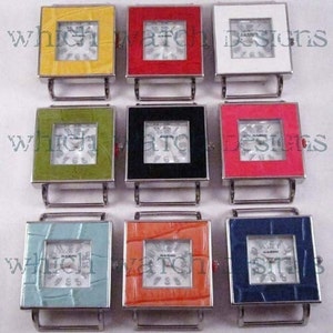 May include: Nine square watch bands with different colored faces and bezels. The colors include yellow, red, white, green, black, pink, blue, and light blue. The watch bands are all silver.