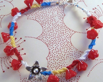 Pulseira da amizade com detalhes em vermelho, amarelo e azul
