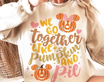 May include: A beige sweatshirt with the text "We go together like pumpkin and pie" in various colors. The design includes pumpkin-shaped Mickey Mouse heads and hearts, perfect for fall and Halloween.