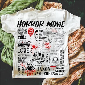 May include: White t-shirt with a graphic design featuring the words "HORROR MOVIE" and various horror movie characters and phrases. The design includes images of Michael Myers, Freddy Krueger, and Jason Voorhees.