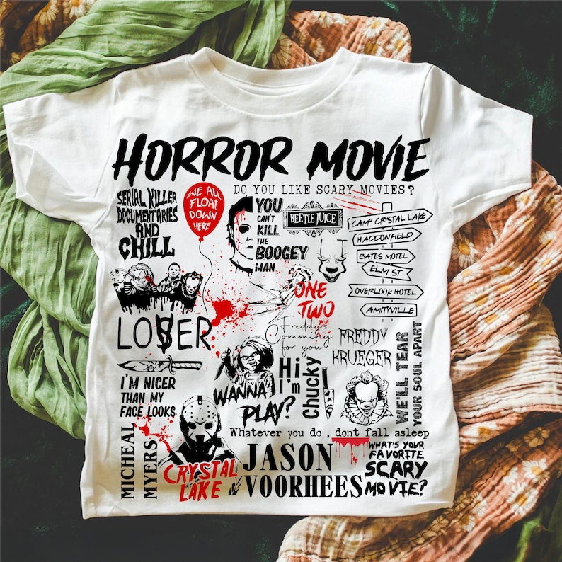 May include: White t-shirt with a graphic design featuring the words "HORROR MOVIE" and various horror movie characters and phrases. The design includes images of Michael Myers, Freddy Krueger, and Jason Voorhees.