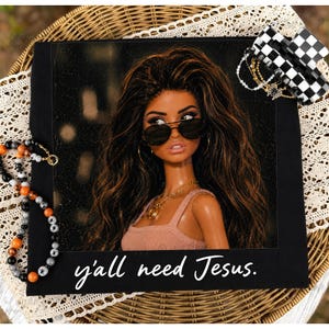 May include: A black t-shirt featuring a graphic of a doll with long brown hair, wearing black aviator sunglasses and a gold chain necklace. The doll wears a light pink tank top. The text "y'all need Jesus." is printed in white script at the bottom.