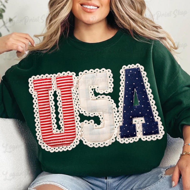 Puede incluir: Sudadera verde oscuro con la palabra "USA" en letras aplicadas blancas, rojas y azules. Las letras est&aacute;n delineadas con un ribete de encaje blanco. La "U" es a rayas rojas y blancas, la "S" es blanca y la "A" es azul marino con lunares blancos.