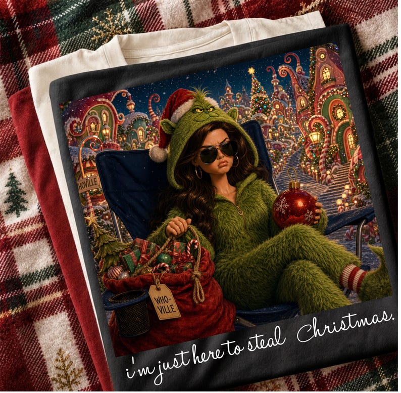 May include: A black t-shirt featuring a graphic of a person in a green fuzzy hooded outfit and sunglasses, holding a red ornament. The scene includes a red sack labeled WHO-VILLE, a blue folding chair, and a festive background with the text I'm just here to steal Christmas.